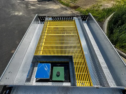 Top deck view with grating and side walkway rails from rear angle.